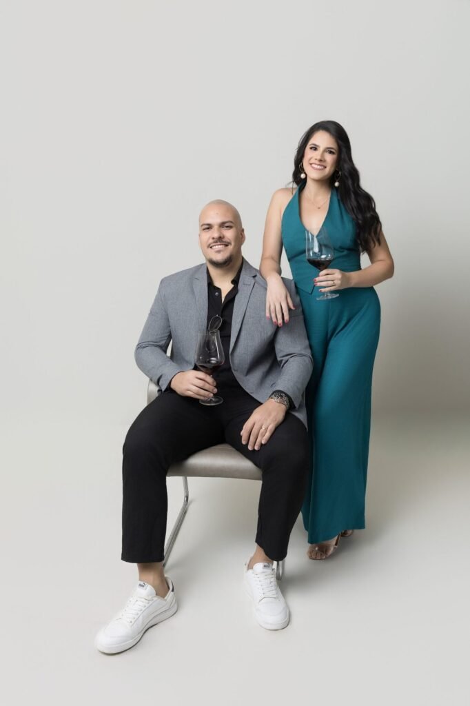Casal de corretores com tacas de vinho em ensaio corporativo de estudio