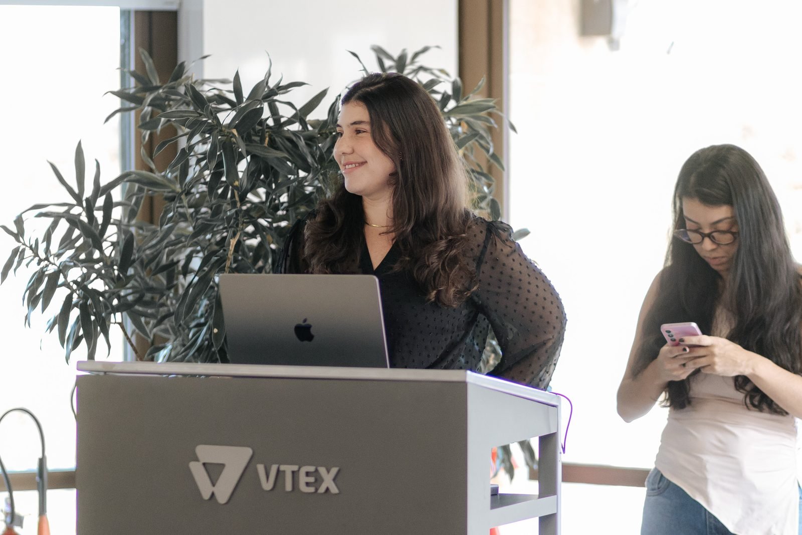 Anfitria da VTEX conduzindo o evento no pulpito do Pink Boost
